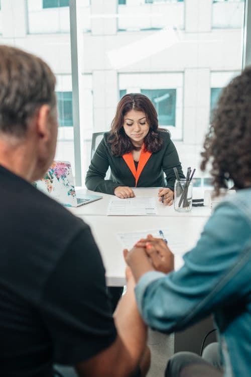 Couple signing estate planning documents with an advisor