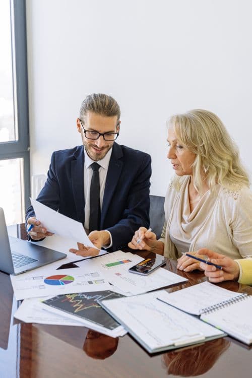 Advisors reviewing financial documents and tax strategy graphs