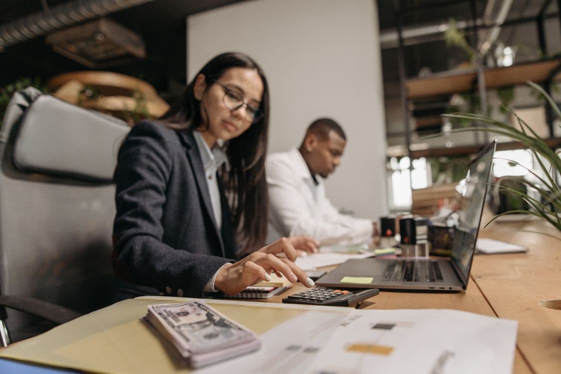 Advisors reviewing tax preparation documents with a calculator
