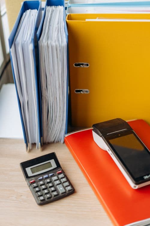 Calculator and financial documents organized on a desk