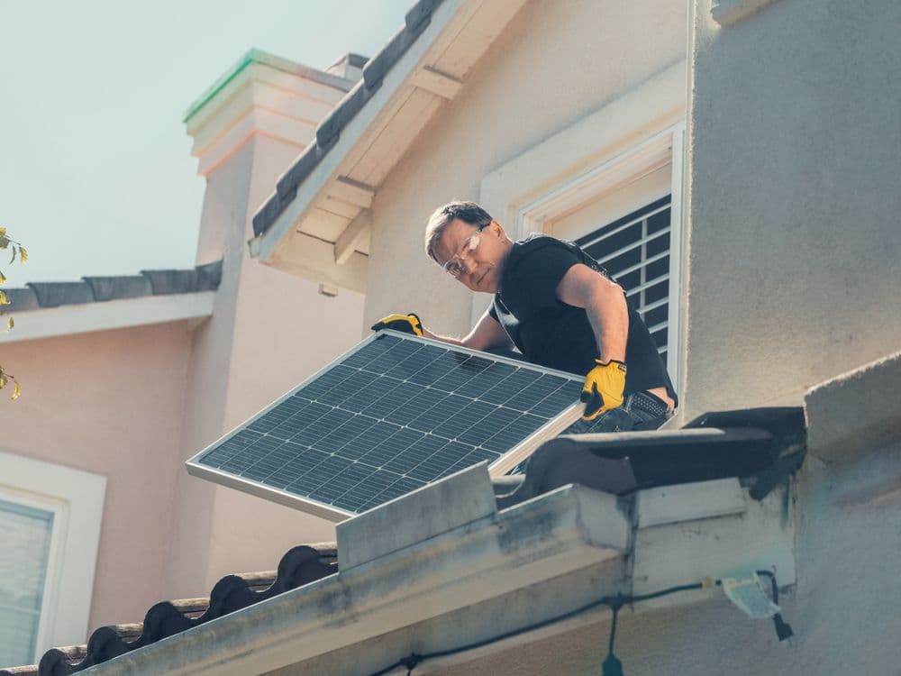 Technician installing solar panels on a roof